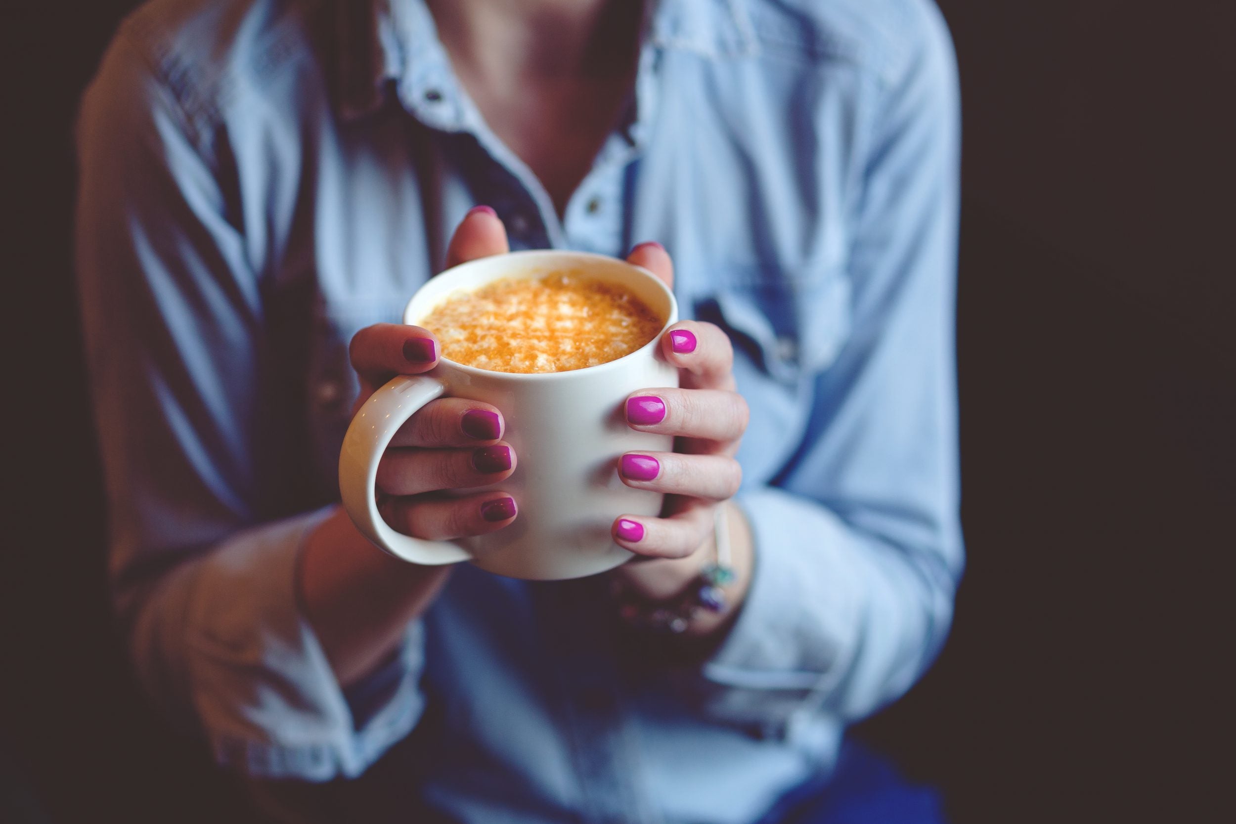 Woman sipping coffee from mug.